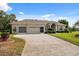 Inviting single-Gathering home featuring a three-car garage and manicured front lawn at 3400 Rosebay Ct, Spring Hill, FL 34609