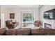 Bright living room with sliding glass doors to the pool and fireplace with a TV, perfect for relaxation at 3400 Rosebay Ct, Spring Hill, FL 34609