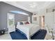 Main bedroom featuring a tray ceiling, gray accent wall, transom window, and ensuite bathroom at 3400 Rosebay Ct, Spring Hill, FL 34609