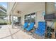 Relaxing outdoor patio with comfortable blue seating, a ceiling fan, and screened-in enclosure at 3400 Rosebay Ct, Spring Hill, FL 34609