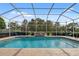 Beautiful screened-in pool area, complete with a serene waterfall feature and lush landscaping at 3400 Rosebay Ct, Spring Hill, FL 34609