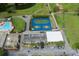 Aerial shot showcasing tennis courts, pools, and clubhouse with lush green spaces in the community at 3544 Teeside Dr # 1, New Port Richey, FL 34655