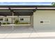 Exterior covered parking adjacent to the home, landscaping, and gray roof at 3544 Teeside Dr # 1, New Port Richey, FL 34655