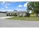 Single-story home with colorful landscaping, lush green lawn, and mature trees at 3544 Teeside Dr # 1, New Port Richey, FL 34655