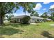 Exterior view of the home with a well-maintained lawn, landscaping, and a gray roof at 3544 Teeside Dr # 1, New Port Richey, FL 34655