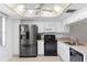 Bright kitchen features stainless steel refrigerator and range, with white cabinetry at 3544 Teeside Dr # 1, New Port Richey, FL 34655