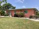 A view of the home's backyard showing grass, trees, plants, and the home's exterior at 406 Driftwood E Dr, Palm Harbor, FL 34683