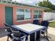 Backyard patio with table and chairs overlooking the outdoor space with a privacy fence at 406 Driftwood E Dr, Palm Harbor, FL 34683