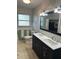 Bathroom featuring a double vanity and shower, complemented by a window for natural light at 406 Driftwood E Dr, Palm Harbor, FL 34683