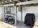 Covered outdoor bar area with counter seating, lighting, fan, and grill at 406 Driftwood E Dr, Palm Harbor, FL 34683