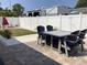 A backyard patio featuring a table and chairs and enclosed by a white vinyl fence at 406 Driftwood E Dr, Palm Harbor, FL 34683
