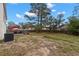 Expansive backyard with mature trees, a patio, BBQ, and ample space for recreation at 4148 Landover Blvd, Spring Hill, FL 34609