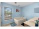 Well-lit bathroom with a large soaking tub, window, and neutral color palette, perfect for relaxation at 4148 Landover Blvd, Spring Hill, FL 34609