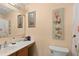 A well-lit bathroom featuring a sink and vanity with decorative wall art and soft peach-painted walls at 4148 Landover Blvd, Spring Hill, FL 34609