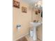A charming bathroom with unique pedestal sink, decorative art, and a soft, inviting rug at 4148 Landover Blvd, Spring Hill, FL 34609