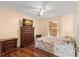 Cozy bedroom featuring a floral bedspread, ceiling fan, and television on an ornate wooden dresser at 4148 Landover Blvd, Spring Hill, FL 34609
