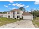 Charming two-story home with an attached garage and a long, inviting driveway and blue front door at 4148 Landover Blvd, Spring Hill, FL 34609