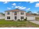 Charming two-story home with a well-maintained lawn, attached garage, and welcoming blue front door at 4148 Landover Blvd, Spring Hill, FL 34609