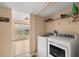 Modern laundry area with washer and dryer, storage shelving, and access to a bright, sunny room at 4148 Landover Blvd, Spring Hill, FL 34609