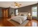 Spacious bedroom featuring wood floors, ceiling fan, and lots of natural light from the windows at 4190 Lema Dr, Spring Hill, FL 34609