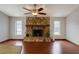 Cozy living room with a stone fireplace, wood floors and large windows at 4190 Lema Dr, Spring Hill, FL 34609