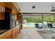 Outdoor patio with tiled floor, wet bar, and a view of a screened-in pool at 4190 Lema Dr, Spring Hill, FL 34609