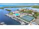 Aerial view of the Gulf Harbour Yacht Club, featuring a pool, tennis courts, and boat docks on the water at 4420 Marine Pkwy, New Port Richey, FL 34652