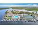 Aerial view of the Gulf Harbour Yacht Club, featuring a pool, tennis courts, and boat docks on the water at 4420 Marine Pkwy, New Port Richey, FL 34652