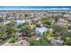 Aerial view of the property showcasing the neighborhood, a nearby body of water, and mature landscaping at 4420 Marine Pkwy, New Port Richey, FL 34652