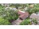 Birds-eye view of the house with brown roof, two-car garage, and mature trees in a residential area at 4420 Marine Pkwy, New Port Richey, FL 34652