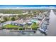 Aerial view of the Gulf Harbour Yacht Club featuring a pool, tennis courts, and boat docks on the water at 4420 Marine Pkwy, New Port Richey, FL 34652