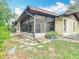An exterior view of the house showing the sunroom with an ADT security sign on the lawn at 4420 Marine Pkwy, New Port Richey, FL 34652
