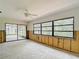 Open living room features large picture window to backyard and sliding glass doors to screen porch at 4420 Marine Pkwy, New Port Richey, FL 34652