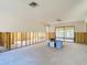 Spacious room with wall studs ready for renovation and sliding glass doors opening to the outdoors at 4420 Marine Pkwy, New Port Richey, FL 34652