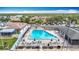 Aerial view of a large community pool with lounge chairs and tables, with palm trees and waterfront in the background at 4420 Marine Pkwy, New Port Richey, FL 34652