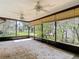 A spacious sunroom featuring two ceiling fans and views of the lush backyard and neighborhood at 4420 Marine Pkwy, New Port Richey, FL 34652