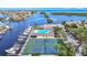 Aerial view of tennis courts, a pool, and a marina, perfect for outdoor recreation and waterfront living at 4420 Marine Pkwy, New Port Richey, FL 34652
