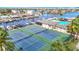Aerial view of pristine tennis courts and a marina, perfect for sports enthusiasts and boating lovers at 4420 Marine Pkwy, New Port Richey, FL 34652