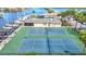 Scenic aerial view of community tennis courts and marina with a view of the waterfront and sailboats at 4420 Marine Pkwy, New Port Richey, FL 34652