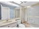 Well-lit bathroom featuring a shower with glass door, vanity with mirror and blue wallpaper at 4837 Boonesboro Ct, New Port Richey, FL 34655