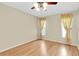 Bedroom with wood floors, two windows with curtains, and ceiling fan at 4837 Boonesboro Ct, New Port Richey, FL 34655