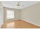 Bright bedroom features a ceiling fan, window for natural light, and wood-look laminate flooring at 4837 Boonesboro Ct, New Port Richey, FL 34655