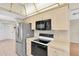 Kitchen featuring stainless steel refrigerator and black range stove and microwave at 4837 Boonesboro Ct, New Port Richey, FL 34655