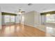 Spacious living area with wood floors, ceiling fan, and transitions to dining and outdoor spaces at 4837 Boonesboro Ct, New Port Richey, FL 34655