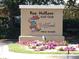 Sign for Fox Hollow Golf Club featuring a whimsical cartoon fox and bright flowers at 4837 Boonesboro Ct, New Port Richey, FL 34655