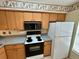 Well-lit kitchen with white refrigerator and black stove top with plenty of cabinet space above and below the counter at 4903 Myrtle Oak Dr # 12, New Port Richey, FL 34653