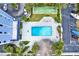Aerial view of a community pool, shuffleboard courts and ample parking at 4939 Floramar Ter # 204, New Port Richey, FL 34652