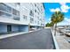 Exterior of waterfront condo building with covered parking, boat docks, and palm trees, providing resort-style living at 4939 Floramar Ter # 204, New Port Richey, FL 34652