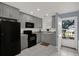 Well-lit kitchen featuring stainless steel appliances, gray cabinets, and granite countertops, offering a blend of style and functionality at 4939 Floramar Ter # 204, New Port Richey, FL 34652