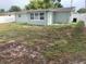 Large backyard with a white vinyl fence and a partial view of the house at 5023 Queen Palm Dr, New Port Richey, FL 34652